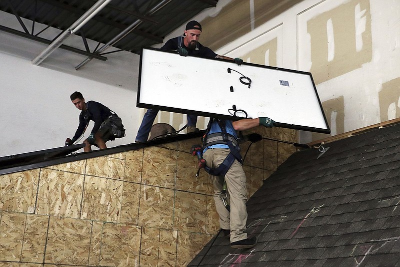 Workers at Sunrun, the largest residential solar power provider in the U.S., demonstrate the company&#x2019;s rooftop solar panel installation process at the company&#x2019;s facility in Des Plaines. (Terrence Antonio James/Chicago Tribune/TNS)