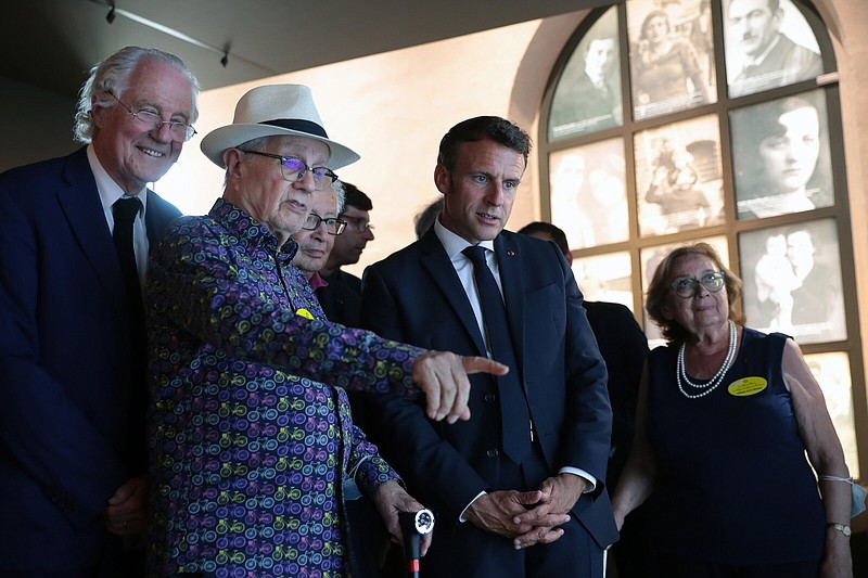 French President Emmanuel Macron, center, visits the newly inaugurated Shoah memorial at the former Pithiviers' train station with Shoah survivor Marcel Sztejnberg, second left, as part of a ceremony commemorating the 80th anniversary of the Vel d'Hiv roundup in Pithiviers, France, Sunday, July 17, 2022. France is holding ceremonies Sunday to commemorate the 80th anniversary of a mass roundup of Jews in Paris under the Nazi occupation. (Christophe Petit Tesson, Pool via AP)