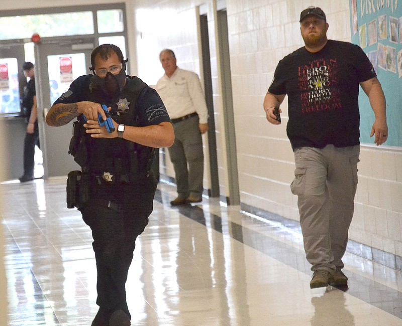 TIMES photographs by Annette Beard
Pea Ridge Police Officer Andrew Day, left, enters the building for an active shooter drill. Pea Ridge, Bella Vista and Little Flock Police officers as well as paramedics and emergency medical technicians from the Pea Ridge Fire-EMS Department worked together training Tuesday and Thursday in an active shooter drill in Pea Ridge Junior High School. For more photographs, go to the PRT gallery at https://tnebc.nwaonline.com/photos/.