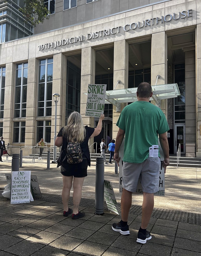 An abortion rights advocate demonstrates outside the 19th Judicial District Courthouse, Monday July 18, 2022, in Baton Rouge, La. (AP Photo/Stephen Smith)