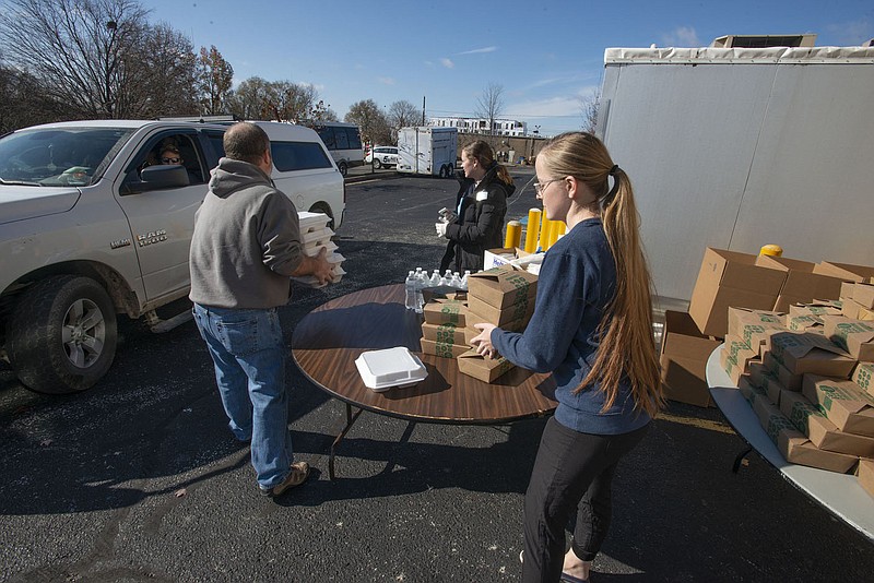 Volunteers Jimmy Blew (from left), Sierra Franklin and Susanna Evans distribute turkey dinners to drivers Nov. 25 at Genesis Church in Fayetteville during the Salvation Army of Northwest Arkansas free Thanksgiving meal event.

(File Photo/NWA Democrat-Gazette/J.T. Wampler)