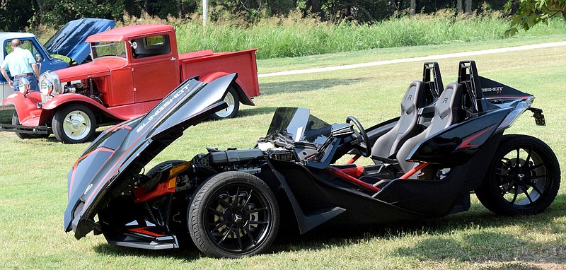 Westside Eagle Observer/MIKE ECKELS A Polaris Slingshot is parked under a tree near the third tee of the Frisbee Golf Course during the 67th Decatur Barbecue at Veterans Park in Decatur on Aug. 7, 2021. Cars, trucks, motorcycles, and three-wheeled vehicles (like this Polaris) will return to Veterans Park in Decatur for the barbecue car show on Aug. 6.