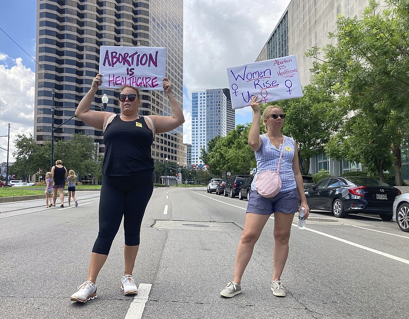 FILE - Protesters wave signs and demonstrate in support of abortion access in front of a New Orleans courthouse on Friday, July 8, 2022. Abortion clinics in Louisiana can continue operating until a lawsuit challenging the state’s near total ban on abortions is resolved, a state judge ruled Thursday, July 21, 2022. (AP Photo/Rebecca Santana, File)