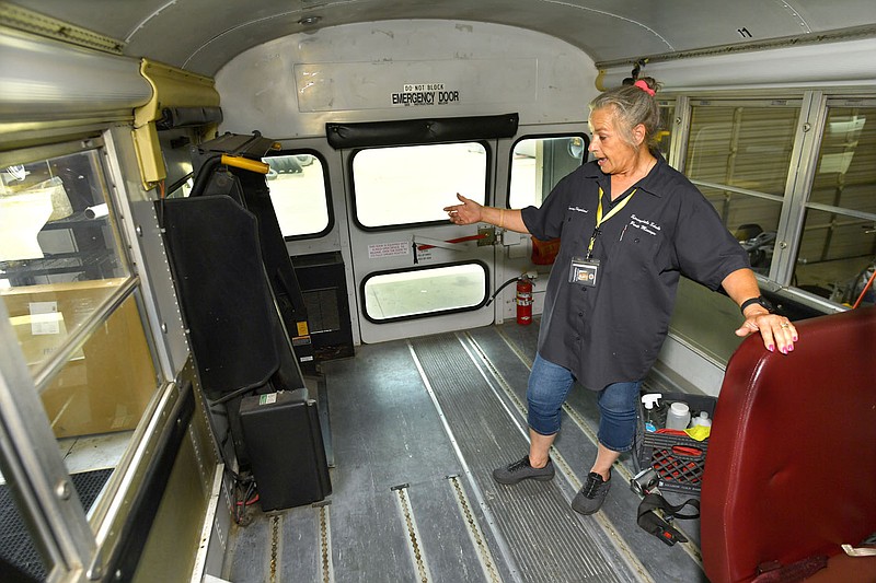 Tammy Shepherd, parts manager for Springdale Public Schools, shows the workings Thursday, July 21, 2022, of a wheelchair lift in one of the districtÃ•s 19 specially equipped school busses at the districtÃ•s maintenance facility in Springdale. The mechanisms in the busses are being tested ahead of the coming school year. Springdale Public Schools, along with many other districts in the state, is facing a bus driver shortage heading into the new school year. Visit nwaonline.com/220723Daily/ for today's photo gallery. 
(NWA Democrat-Gazette/Andy Shupe)