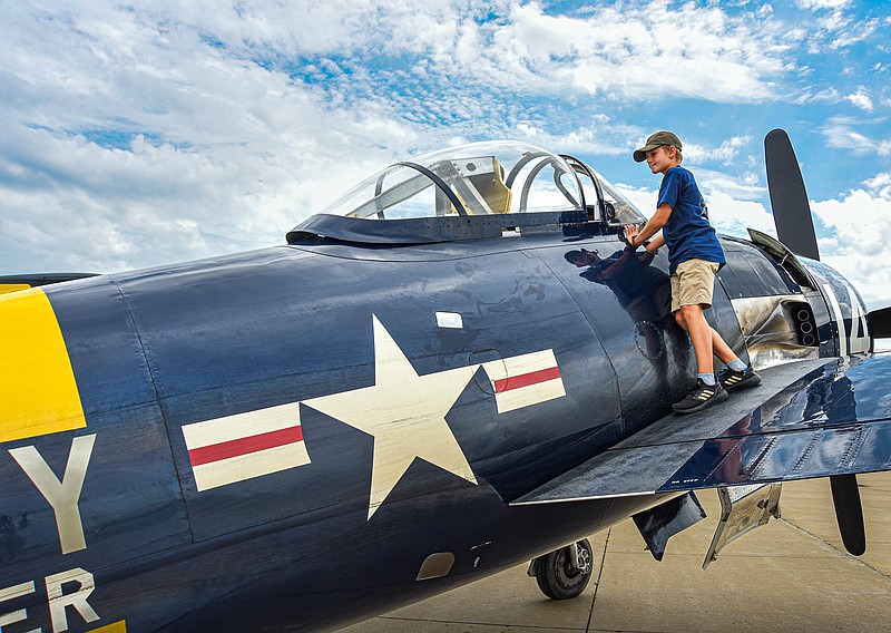 Harry Richardson, 13, of Houston, Texas, has the opportunity to have a first-hand look at how planes were used in World War II Monday, July 25, 2022, as he travels to Oshkosh, Wisconsin with the pilots of Lewis Air Legends. His fascination and passion is contagious as he jumps up on the wing of the F8F-2 Bearcat to demonstrate how to open the canopy. He then wanted to show off the B-25B Mitchell bomber that was part of the group of four planes and how one like it was used in the Doolittle Raid April 18, 1942. (Julie Smith/News Tribune photo)