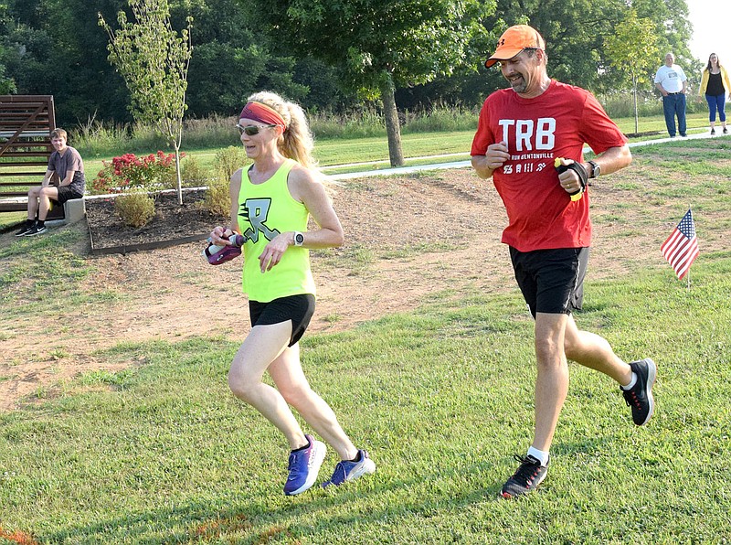Westside Eagle Observer/MIKE ECKELS Two runners inch closer to the finish line after competing in the Decatur Barbecue 5K run along the new walking trail at Veterans Park in Decatur on Aug. 7, 2021. The 5K and Fun Runs are just two of the many opportunities for the public to compete in this year's Decatur Barbecue events on Aug. 6.