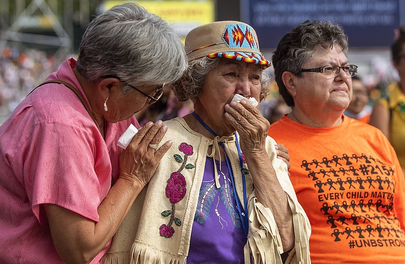 Nancy Saddleman, center, 82, cries as Pope Francis give mass in Edmonton, during his papal visit across Canada on Tuesday July 26, 2022.  (Jason Franson/The Canadian Press via AP)