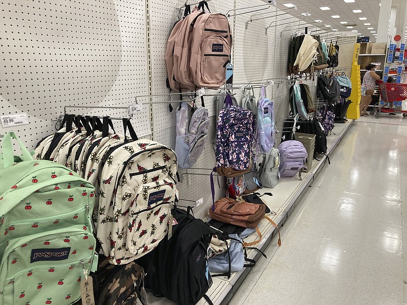 A smattering of backpacks hang on hooks on a display wall in the school supply section of a Target store Wednesday, July 20, 2022, in Aurora, Colo. (AP Photo/David Zalubowski)