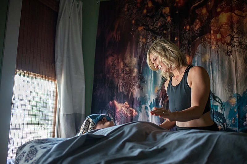 Colleen Narens practices reiki during a private healing session with a client.  Reiki is the Japanese alternative from of energy healing that uses the palms to transfer positive energy from the practitioner to the client.  (Staff photo by Erin DeBlanc)