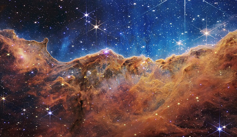 This landscape of "mountains" and "valleys" speckled with glittering stars is actually the edge of a nearby, young, star-forming region called NGC 3324 in the Carina Nebula. Captured in infrared light by NASA’s new James Webb Space Telescope, this image reveals for the first time previously invisible areas of star birth. (NASA, ESA, CSA, and STScI/TNS)