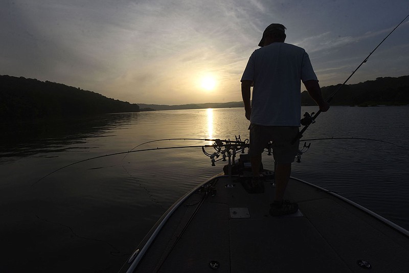 Mitch Glenn of Garfield keeps an eye on fishing rods while trolling crank baits for crappie on June 17 2022 at Beaver Lake.
(NWA Democrat-Gazette/Flip Putthoff)