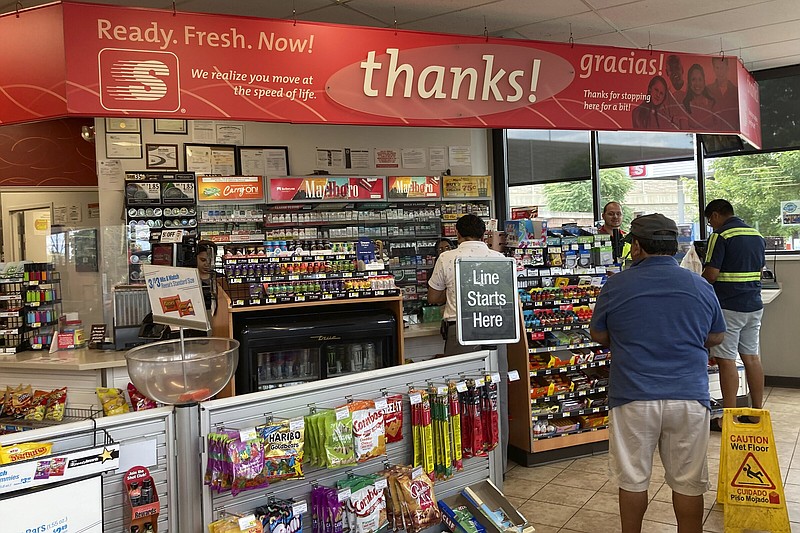 Customers line up to purchase items at the Speedway gas station in Des Plaines, Ill., where the winning Mega Millions lottery ticket was sold, Saturday, July 30, 2022. A ticket-holder in the state clinched the $1.337 billion Mega Millions jackpot from a ticket purchased at the store.  (AP Photo/Nam Y. Huh)