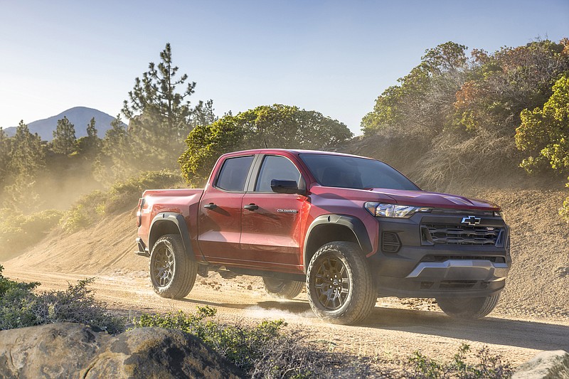 A Chevrolet Colorado Trail Boss drives down a dirt road during golden hour. (Photo by Chevrolet)