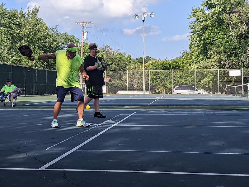 Joseph Smith (left) winds up to serve the Pickleball during a family game Sunday evening, July 31, 2022, at Washington Park in Jefferson City. His nephew, Josiah Waterman, was his match partner. (Ryan Pivoney/News Tribune photo)