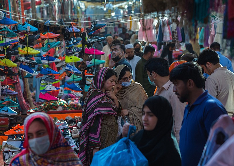 Shoppers near a stall selling shoes at a Sunday market in Karachi, Pakistan, on March 6. MUST CREDIT: Bloomberg photo by Asim Hafeez.