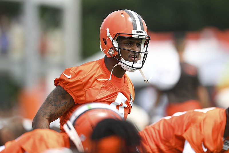 Cleveland Browns quarterback Deshaun Watson stretches during the NFL football team's training camp, Monday, Aug. 1, 2022, in Berea, Ohio. Watson was suspended for six games on Monday after being accused by two dozen women in Texas of sexual misconduct during massage treatments, in what a disciplinary officer said was behavior “more egregious than any before reviewed by the NFL.”  (AP Photo/Nick Cammett)