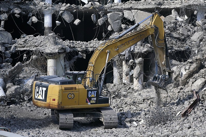FILE - A Caterpillar machine works on the demolition of a building in downtown Pittsburgh Thursday, April 28, 2022. Caterpillar Inc. on Tuesday, Aug. 2 reported second-quarter earnings of $1.67 billion. On a per-share basis, the Deerfield, Illinois-based company said it had net income of $3.13. Earnings, adjusted for restructuring costs, came to $3.18 per share. (AP Photo/Gene J. Puskar, File)