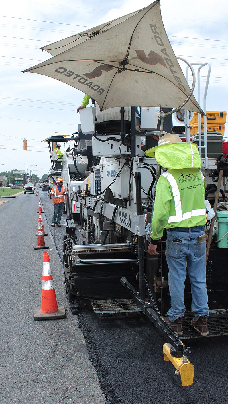 A crew with R.K. Hall Construction apply fresh asphalt to East Street near its intersection with Division Street on Thursday, Aug. 4, 2022, in Texarkana, Ark. The company has been contracted by the Arkansas Department of Transportation to resurface more than 11 miles of the U.S. 71 corridor between East Seventh Street and Fouke, Ark. (Staff photo)