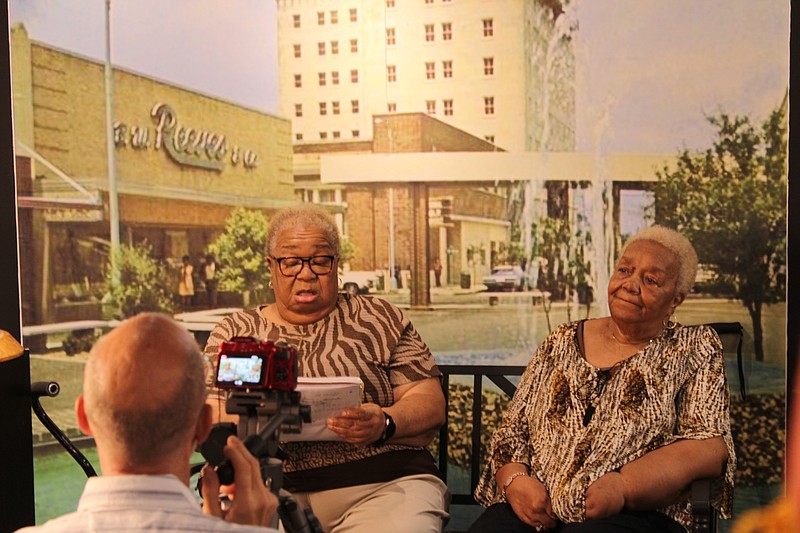 Jean White, left, looks through notes she wrote about growing up near the St. Louis addition in El Dorado as Virginia Charles reminisces. Darrin Riley, facing away, filmed an interview Thursday at the Gallery of History with the women, who were cousins of the late Lonnie Mitchell, as they recalled growing up in El Dorado's Black neighborhoods during segregation and their cousin's impact on the community, as part of the El Dorado Historic District Commission's project to identify an African American context to the city's history. (Caitlan Butler/News-Times)