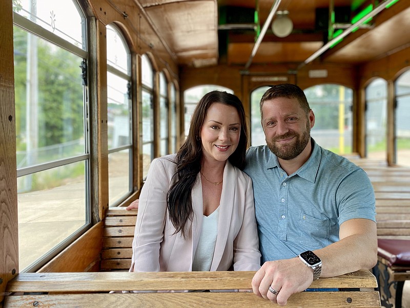 Stephanie and Chris Bell, the new owners of The Trolley Company, pose in one of their trollies. (Cameron Gerber/News Tribune photo)