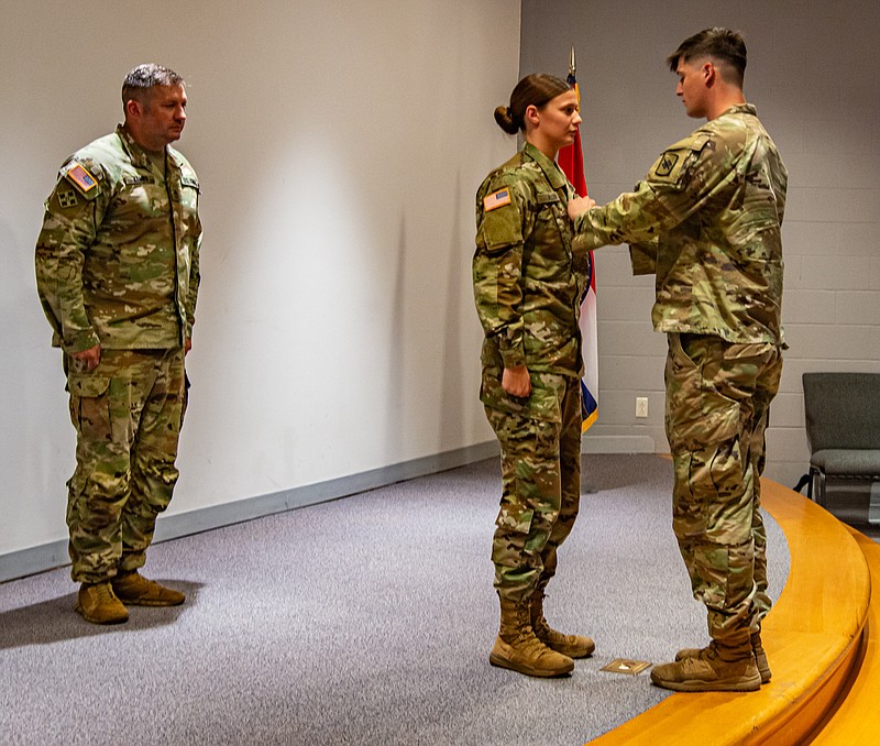 SFC Eric Kemna stands at attention while Sgt. Matthew Allen pins Sergeant stripes on his sister, Sgt. Katy Allen Saturday at Missouri National Guard Armory.  (Ken Barnes/News Tribune)