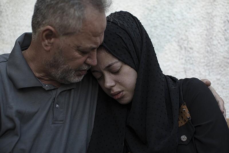Relatives of Ismail Dweik, who was killed in an Israeli airstrike, mourn before his funeral, outside a hospital in Rafah, in the southern Gaza Strip, Sunday, Aug. 7, 2022. An Israeli airstrike in Rafah killed a senior commander in the Palestinian militant group Islamic Jihad, authorities said Sunday, its second leader to be slain amid an escalating cross-border conflict. (AP Photo/Fatima Shbair)