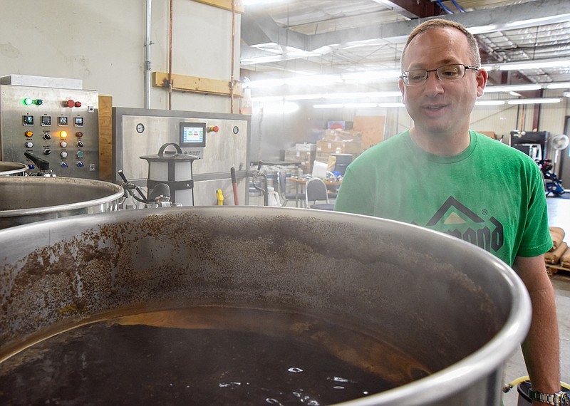 Fr. Jason Doke is shown behind the steam created by the beer as it boils Monday, Aug. 8, 2022, at Last Flight Brewing Co. in Jefferson City. Doke, who is a brewing hobbyist, was invited to brew a keg of beer, a porter, that will be enjoyed in early September by him and St. Martin Catholic Church parishioners as part of Pews and Brews. (Julie Smith/News Tribune photo)