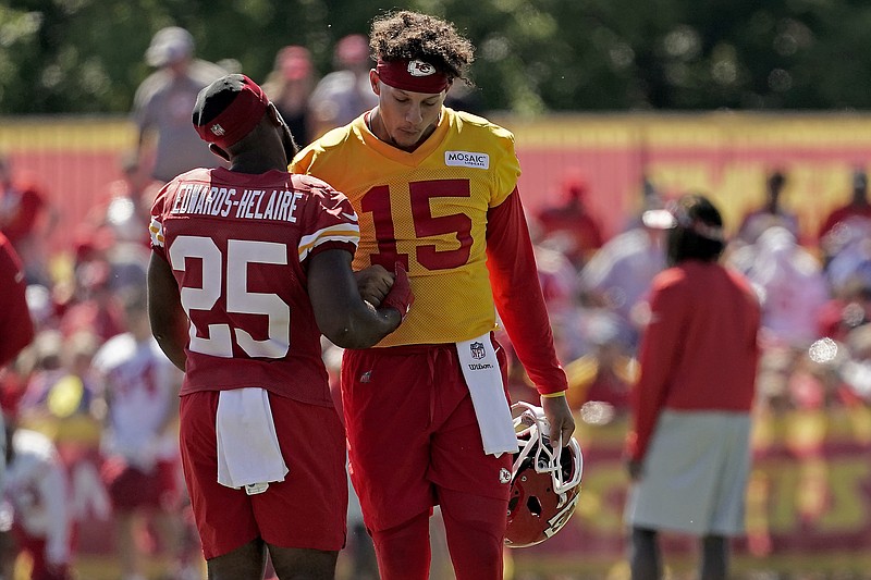 Kansas City Chiefs quarterback Patrick Mahomes (15) and running back Clyde Edwards-Helaire greet each other during NFL football training camp Saturday, July 30, 2022, in St. Joseph, Mo. (AP Photo/Charlie Riedel)