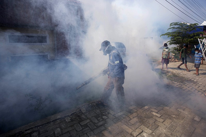 FILE - A worker fumigates a neighborhood with anti-mosquito fog to control dengue fever in Medan, North Sumatra, Indonesia, Feb. 1, 2022. Climate hazards such as flooding, heat waves and drought have worsened more than half of the hundreds of known infectious diseases in people, such as zika, dengue, hantavirus, cholera and even anthrax, according to a new study released Monday, Aug. 8. (AP Photo/Binsar Bakkara, File)