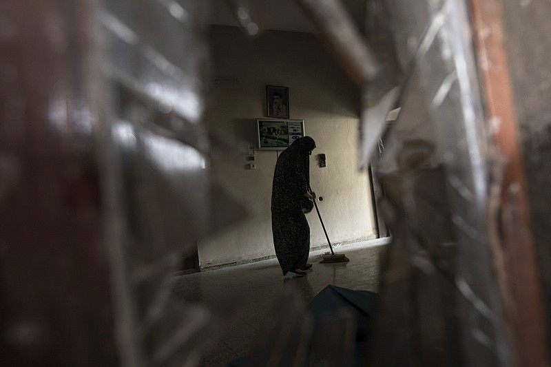 Una mujer palestina limpia su casa dañada tras un ataque israelí en Rafah, en el sur de la Franja de Gaza, el domingo 7 de agosto de 2022. (AP Foto/Fatima Shbair)