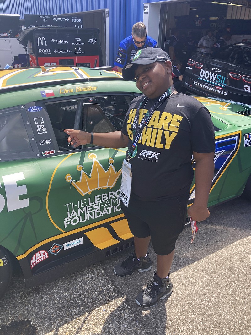 James Bromsey III, a sixth-grader at LeBron James' I Promise School in Akron, Ohio, looks at NASCAR driver Chris Buescher's car Sunday in Brooklyn, Mich. -  Photo by Larry Lage of The Associated Press