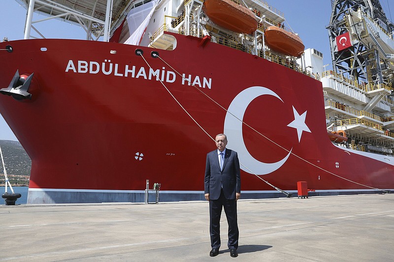 In this photo provided by the Turkish Presidency, Turkey's President Recep Tayyip Erdogan stands in front of Abdulhamid Han ship, in Mersin, Turkey, Tuesday, Aug. 9, 2022. Erdogan inaugurated the country's newest and largest undersea hydrocarbon drill ship Tuesday that he said would head for a spot northwest of Cyprus in the eastern Mediterranean, which is not claimed by any other country. Turkey is embroiled in acrimonious disputes with Greece and Cyprus over maritime boundaries and offshore energy rights, which triggered high tensions in the eastern Mediterranean two years ago. (Turkish Presidency via AP)