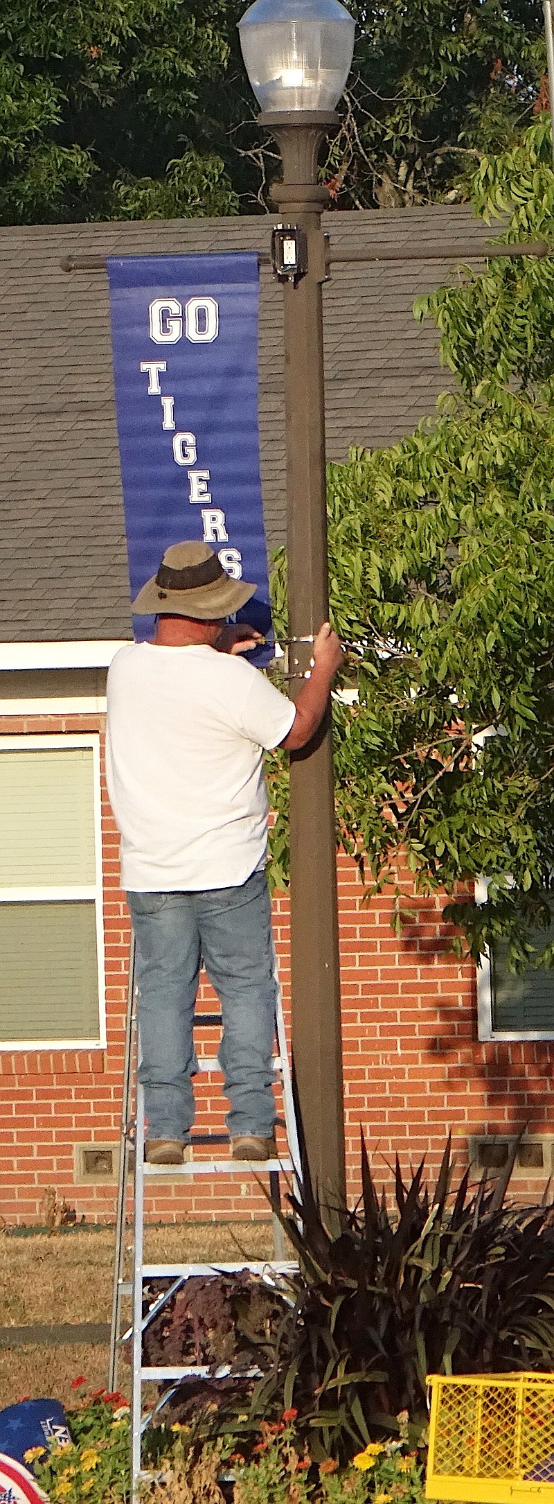 It’s football time on the square in Linden as well as for the Linden-Kildare School District. On Monday, city employee Michael Riley was putting up the banners showing support. Courthouse banners get changed four to five times a year to remain colorful and interesting. (Staff photo by Neil Abeles)