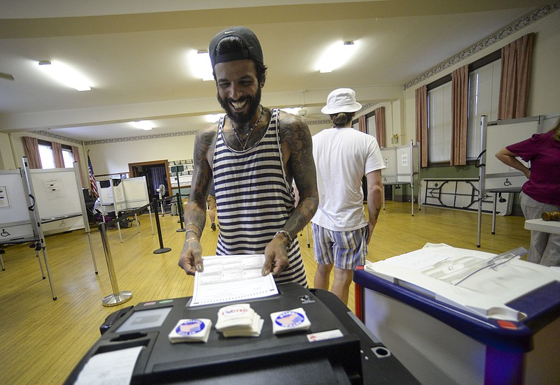 Alain Martinez, of Bellows Falls, smiles when submitting the ballot in the state's primary election, Tuesday, Aug. 9, 2022, in Bellows Falls, Vt. (Kristopher Radder/The Brattleboro Reformer via AP)