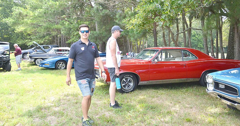 Richie Logan, president of the Arkansas River Chapter of the Pontiac and GMC Club of Northwest Arkansas, is shown with several of the Pontiacs on display Aug. 6 at the home of Gene and Teresa Newman for a show.

(NWA Democrat-Gazette/Annette Beard)