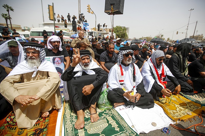Supporters of the Shiite cleric Muqtada al-Sadr hold prayer near the parliament building in Baghdad, Iraq, Friday, Aug. 12, 2022. Al-Sadr's supporters continue their sit-in outside the parliament to demand early elections. (AP Photo/Anmar Khalil)