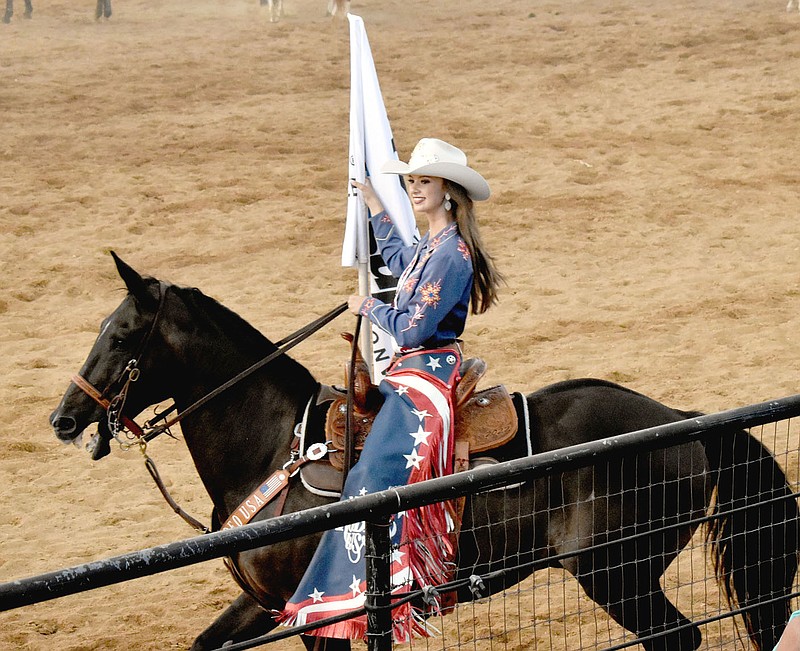 MARK HUMPHREY  ENTERPRISE-LEADER/Miss Teen Rodeo USA Ashley Polson, shown carrying a sponsor's flag Saturday, was among the guest royalty making appearances the 69th annual Lincoln Riding Club Rodeo.