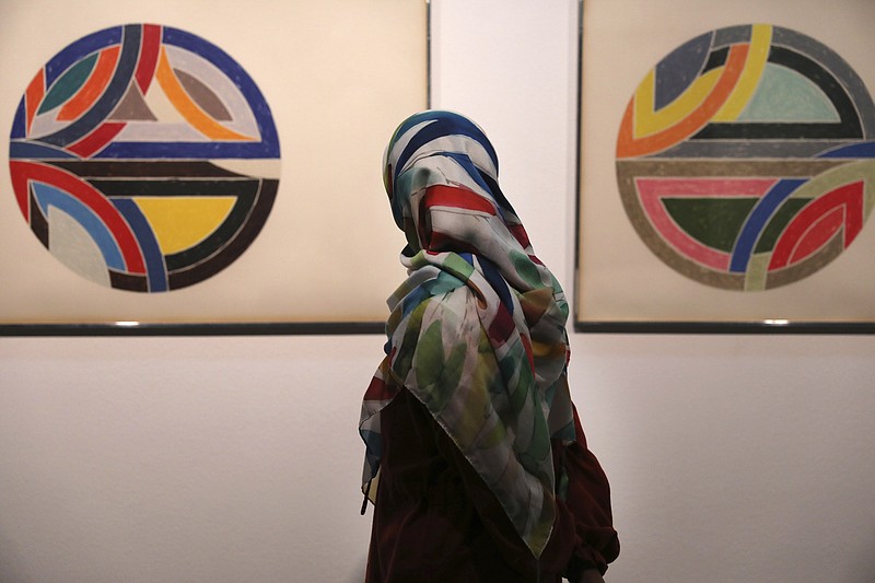 Una visitante observa la obra del pintor estadounidense Frank Stella, Sinjerli Variations No. 1-5- 1977, en una exposición de arme minimalista y conceptual estadounidense y europeo de los siglos XIX y XX, en el Museo de Arte Contemporáneo de Teherán, en Teherán, Irán, el 2 de agosto de 2022. (AP Foto/Vahid Salemi)