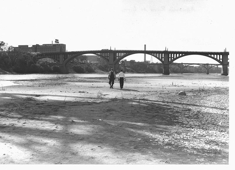 Two men stroll south from North Little Rock on Sept. 12, 1956, toward a shallow, depleted Arkansas River glittering below the old 1924 Main Street Bridge. Before the McClellan-Kerr Navigation System, the river swelled and shrank with the seasons; but from July 1949 to September 1957 intense drought parched the region and the river sank to historic lows. (Democrat-Gazette archives)