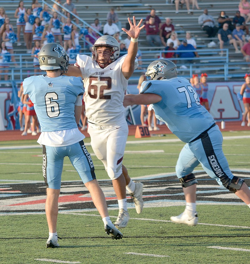 Graham Thomas/Herald-Leader
Siloam Springs defensive lineman Saul Urena leaps in front of Fort Smith Southside quarterback George Herrell during an Arkansas Activities Association benefit game Tuesday, Aug. 16, at Jim Rowland Stadium in Fort Smith.