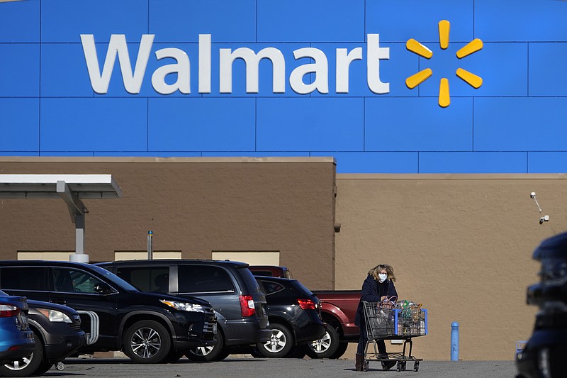 A woman wheels a cart with her purchases out of a Walmart, on Nov. 18, 2020, in Derry, N.H. Walmart, the nation’s largest employer, is expanding its abortion coverage for employees, according to a memo sent to employees Friday, Aug. 19, 2022, after staying mum on the topic for months following the Supreme Court ruling that scrapped a nationwide right to abortion. (AP Photo/Charles Krupa, File)