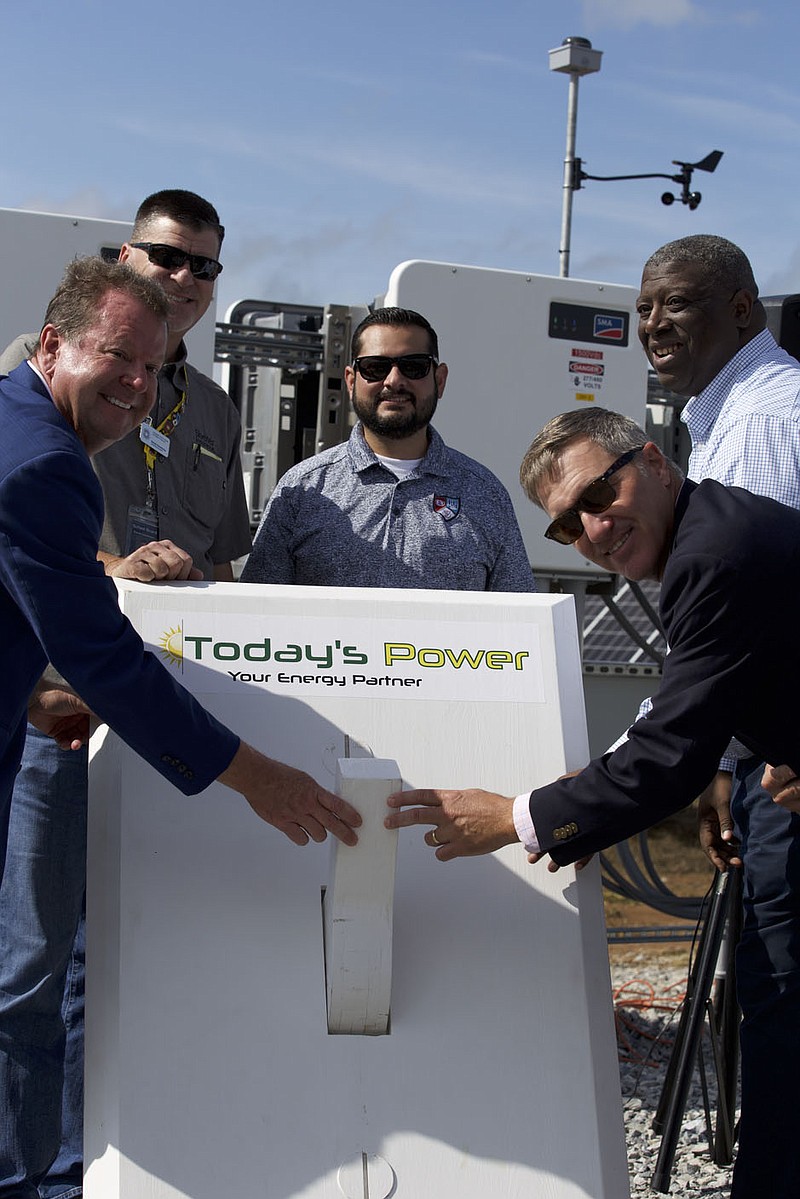 Mitchell Johnson, CEO of Ozarks Electric Cooperative; Randy Hutchinson, Springdale school board president; Eddie Ramos, school board member; Derek Dyson, CEO of Today's Power, Inc.; and Jared Cleveland, superintendent of Springdale Schools  ceremonially flipped the switch Monday for a new solar power facility and battery storage system near Sonora Middle School. (Mary Jordan/Springdale School District).