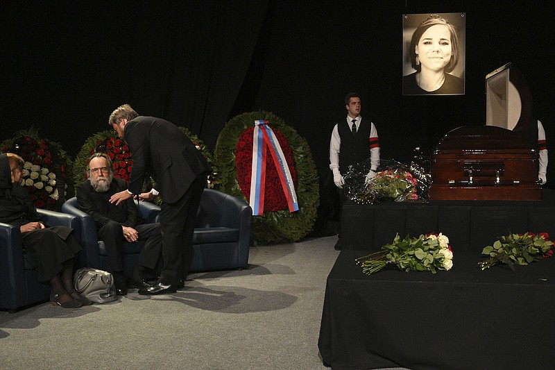 Philosopher Alexander Dugin, left, attends the final farewell ceremony for his daughter Daria Dugina in Moscow, Russia, Tuesday, Aug. 23, 2022. Daria Dugina, a 29-year-old commentator with a nationalist Russian TV channel, died when a remotely controlled explosive device planted in her SUV blew up on Saturday night as she was driving on the outskirts of Moscow, ripping the vehicle apart and killing her on the spot, authorities said. (AP Photo/Dmitry Serebryakov)