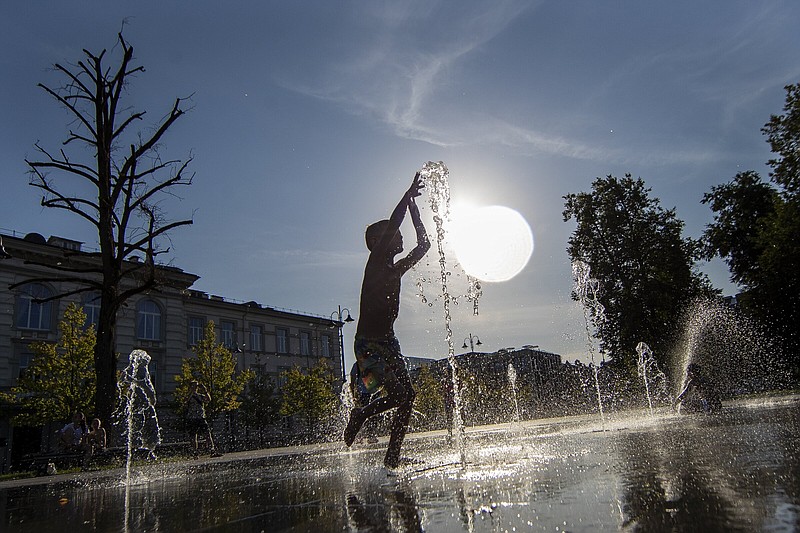 A boy cools off in a public fountain in Vilnius, Lithuania, Friday, Aug. 19, 2022. Hot weather has set in with temperatures rising up to 34 degrees Celsius (93.2 degrees Fahrenheit) in Lithuania. (AP Photo/Mindaugas Kulbis)