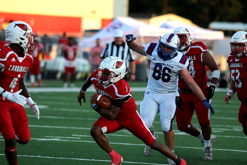 Martavious Thomas (1) looks for the endzone as Trent Haygood (4) sets up a block. The Cardinals went scoreless in the second half. - Photo by Charlie Olds