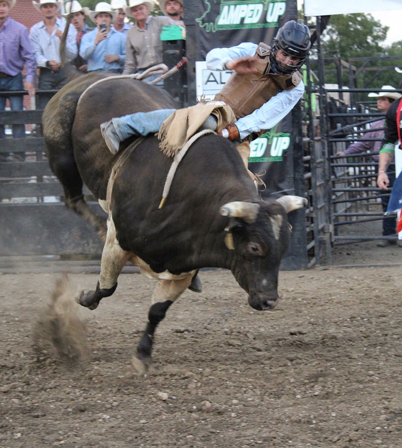 A rider in the Amped Up Pro Bull Riding Tour tries to keep his balance during event at the Moniteau County Fairgrounds on Saturday, Aug. 27, 2022. (Democrat photo/Kaden Quinn)