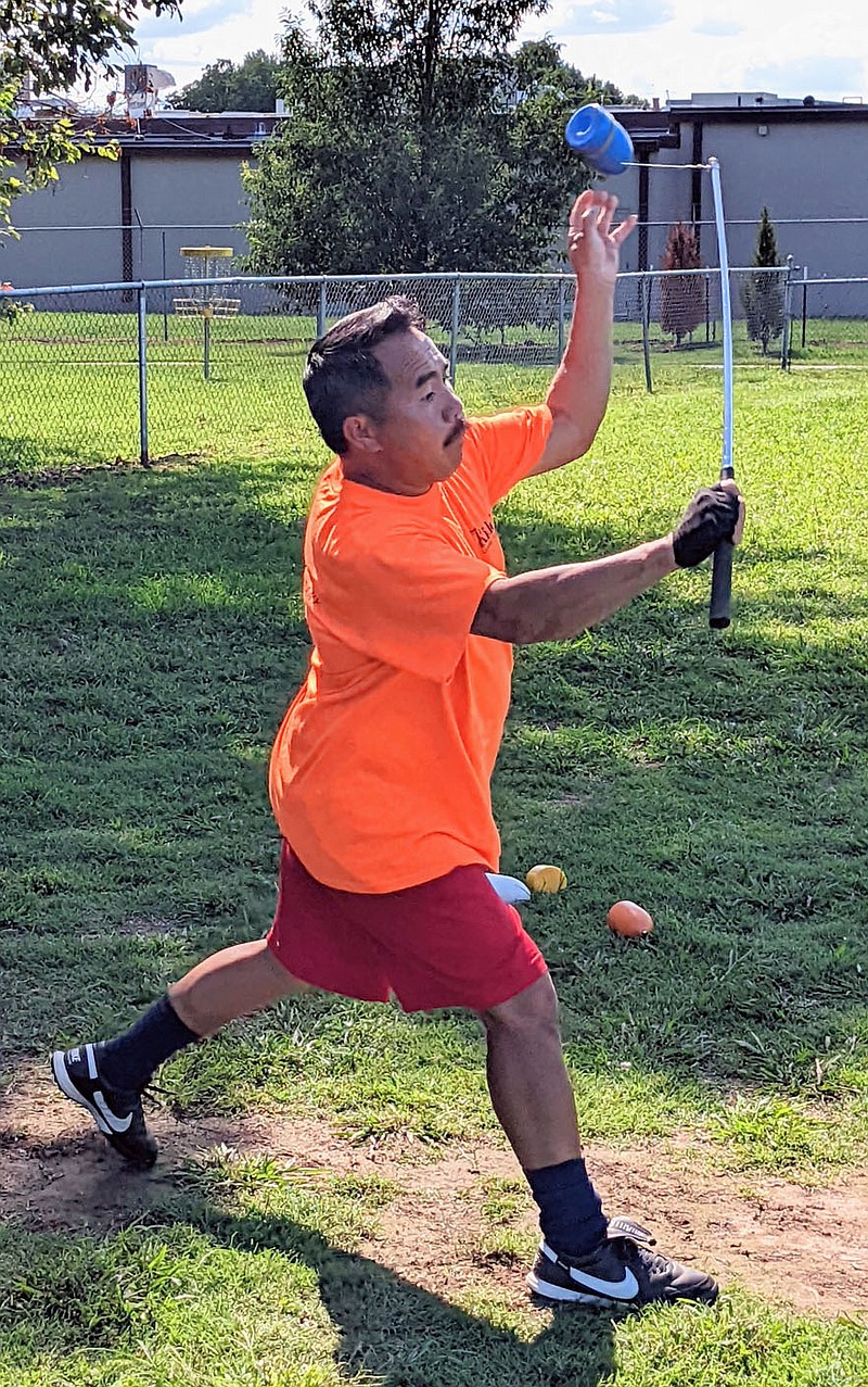 Westside Eagle Observer/RANDY MOLL
Keng Vang throws a top as he practices before a twice-weekly game of Tuj Lub in Gentry City Park on Aug. 30.