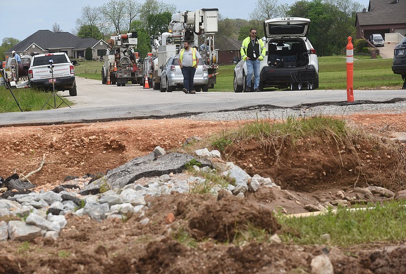 Josh Beam (left), Benton County engineer, and Michael Waddle, county emergency management director, look Wednesday May 12 2021 at flood damage to Col. Meyers Road 100 yards north of Wager Road in Cave Springs. (NWA Democrat Gazette/Flip Putthoff)
