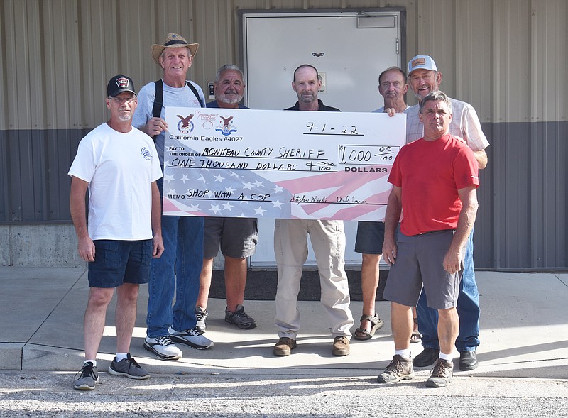 The California Fraternal Order of Eagles present the Moniteau County Sheriff Office with a check Thursday (Sept. 1, 2022,) in front of the FOE building for the annual Shop With a Cop program. Pictured, from left, is: Tom Winters, California FOE President Steve Liebi, Charlie Roll, Sheriff Tony Wheatley, Rick Smith, Dave Turner and Greg Buschjost. Underprivileged children are able to shop for new toys with law enforcement officers during the annual event held before Christmas. (Democrat photo/Garrett Fuller)