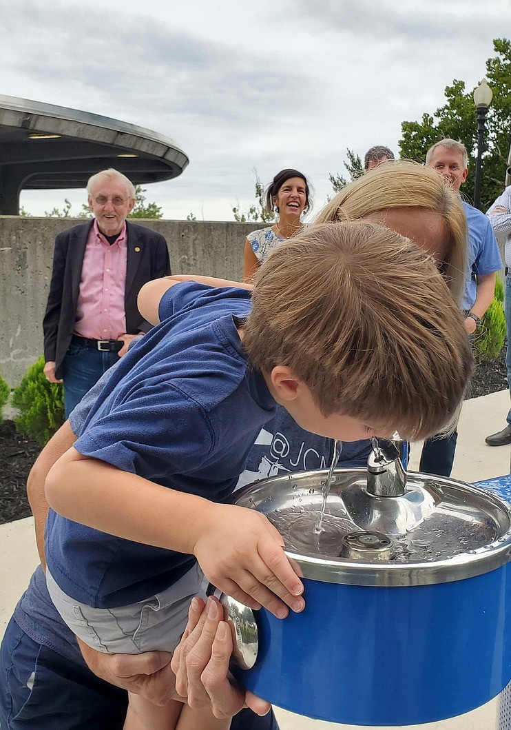 Jeff Haldiman/News Tribune
Luke Wisch, 3, of Jefferson City, takes a drink from the new hydration station, located at the start of the path to the Bicentennial Bridge. Helping Luke get that drink is his grandmother, Karen Wisch. State Rep. Rudy Viet of Wardsville, Jefferson City Mayor Carrie Tergin and Bob Gilbert of Bartlett and West Engineering look on during a dedication ceremony Friday morning.